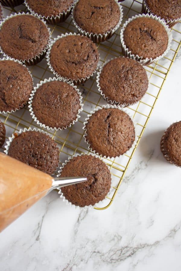 filling cupcakes with nutella cream in cupcake filler.