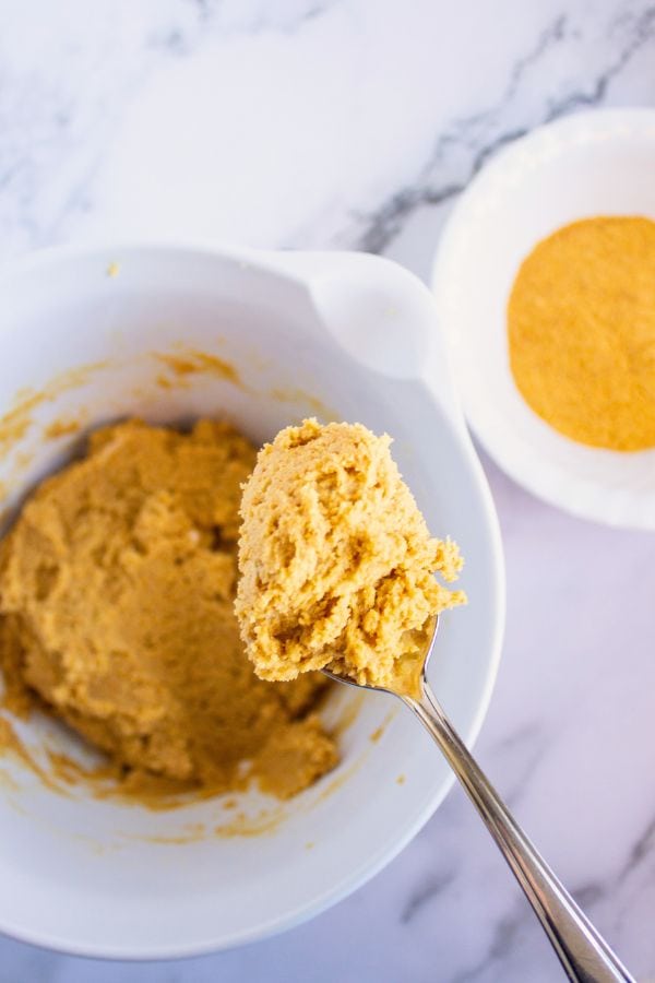 graham cracker cookie mixture on spoon above bowl.