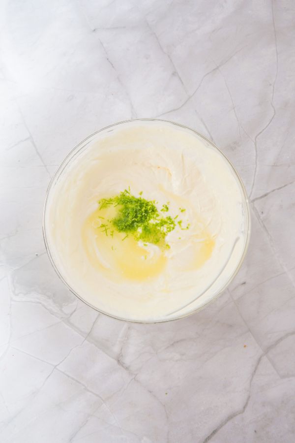 key lime cream mixture with lime juice and zest on top.
