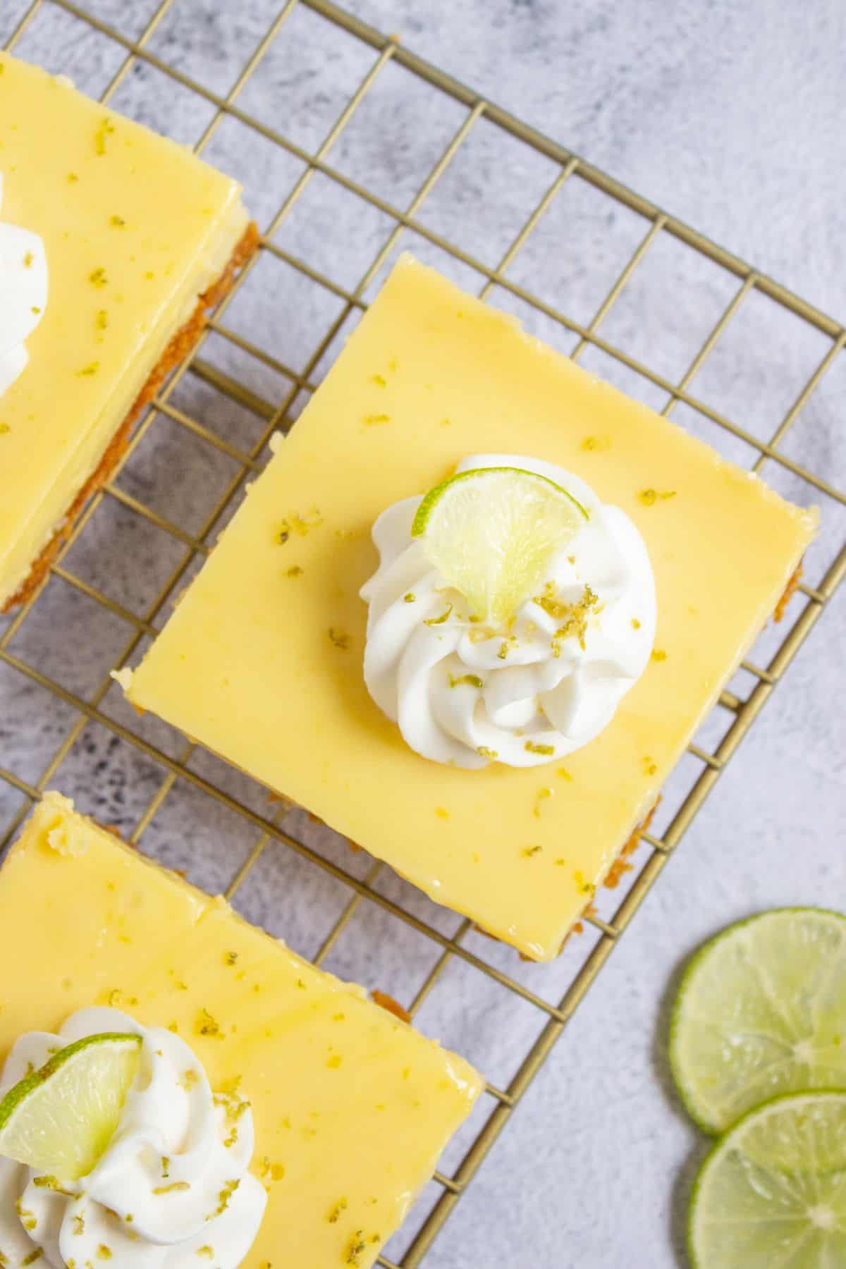 garnished key lime dessert squares on wire rack.