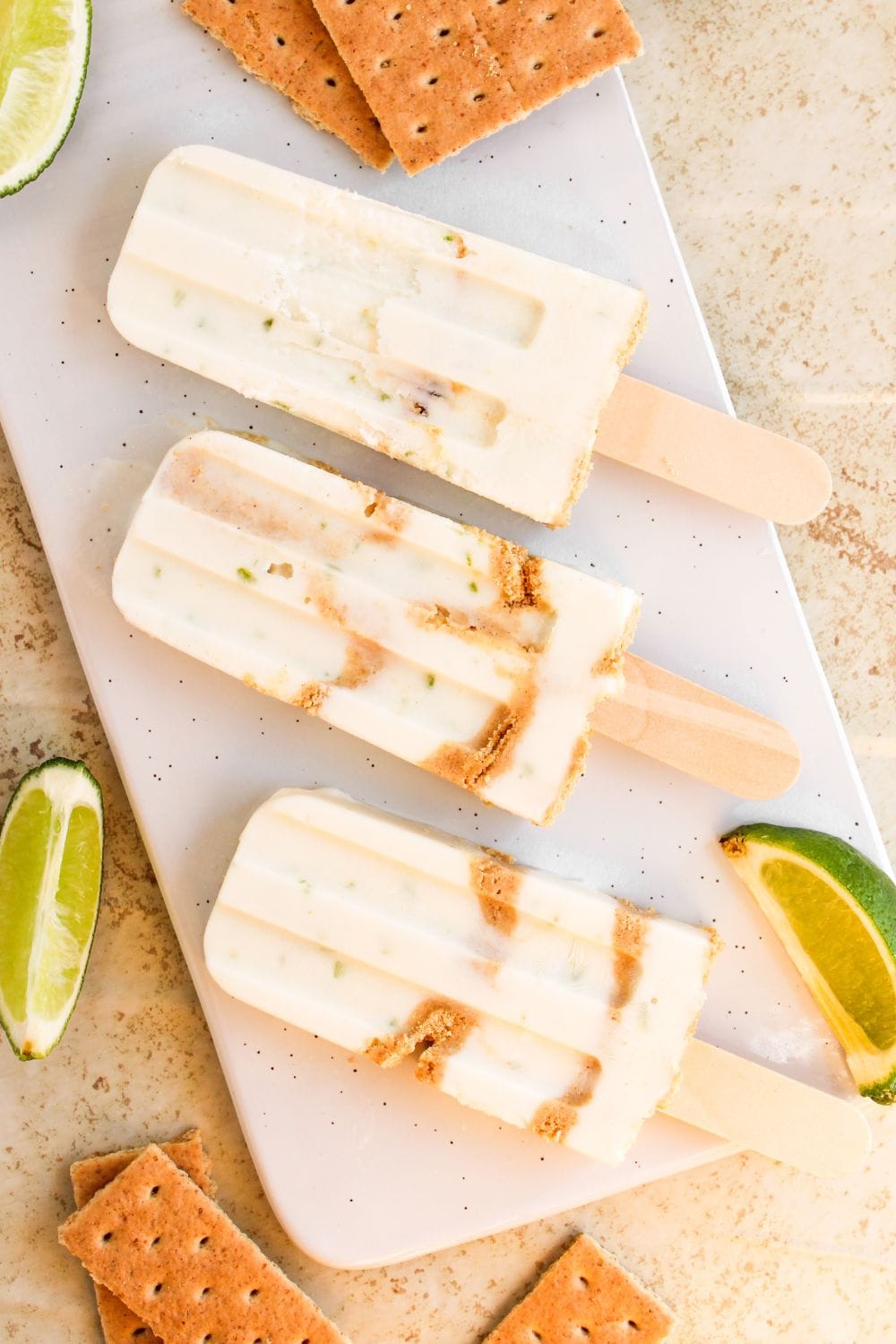 key lime pie popsicles on white platter.