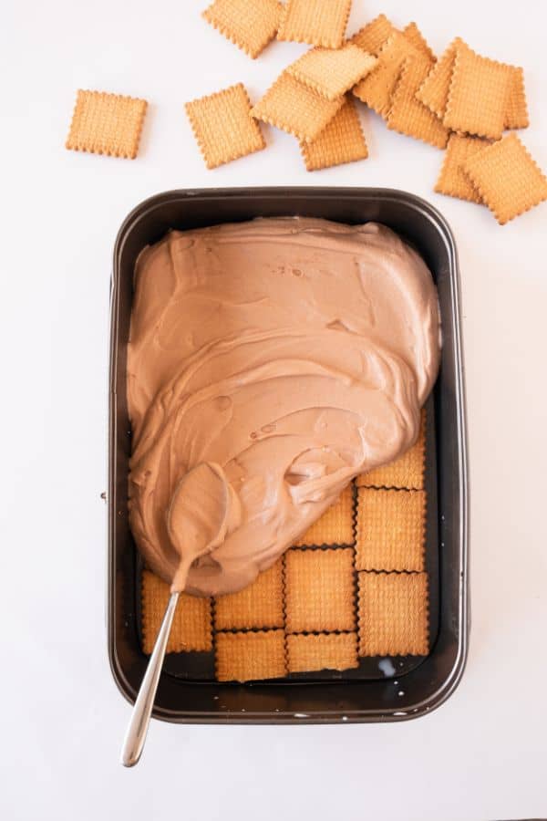 layering biscoff cream on tea biscuits.