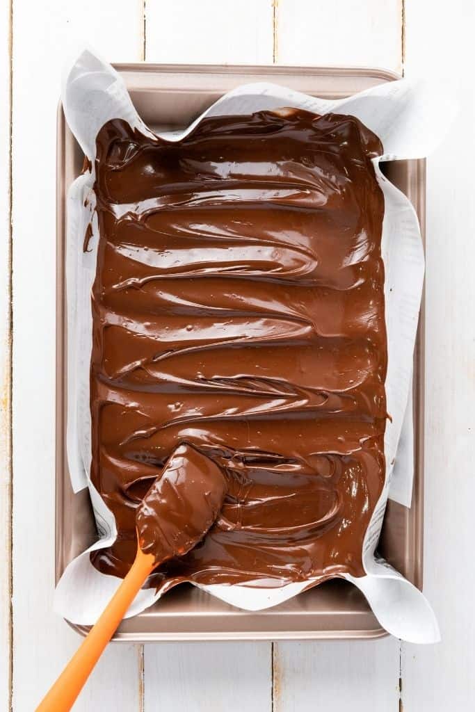 spreading melted chocolate in pan.