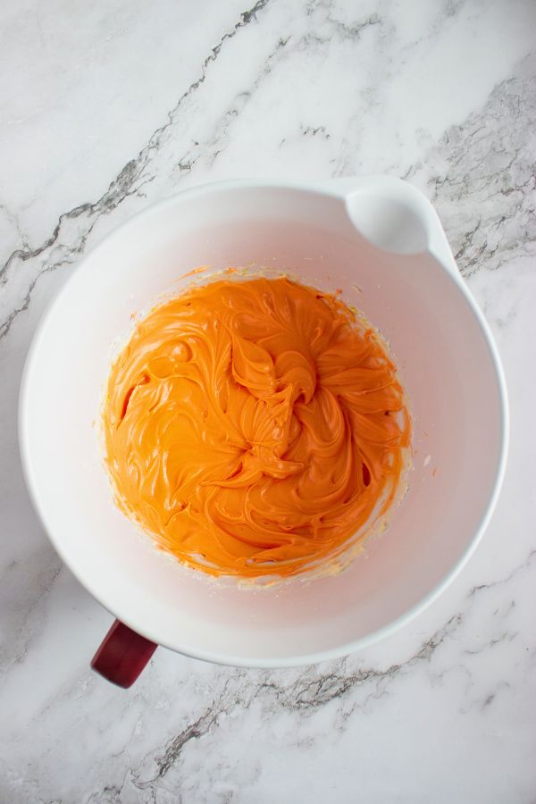 orange flame colored frosting in bowl.