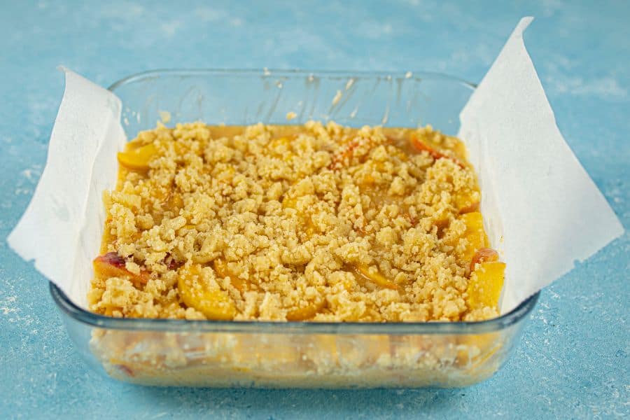 peach crumble bars assembled in pan.