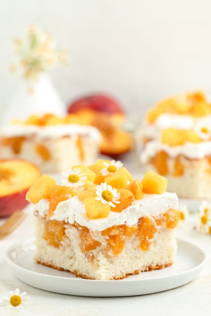 slice of peach poke cake on plate.