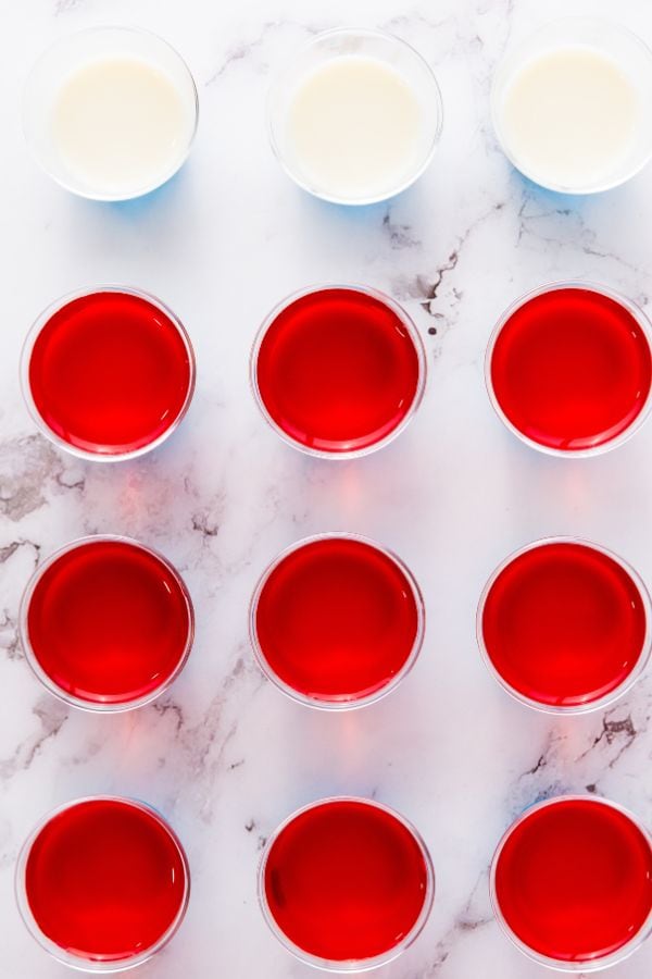 red and white layered jello in cups.
