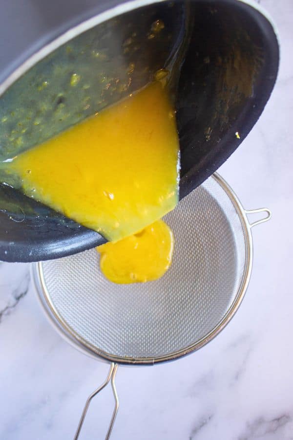straining lime curd into bowl.