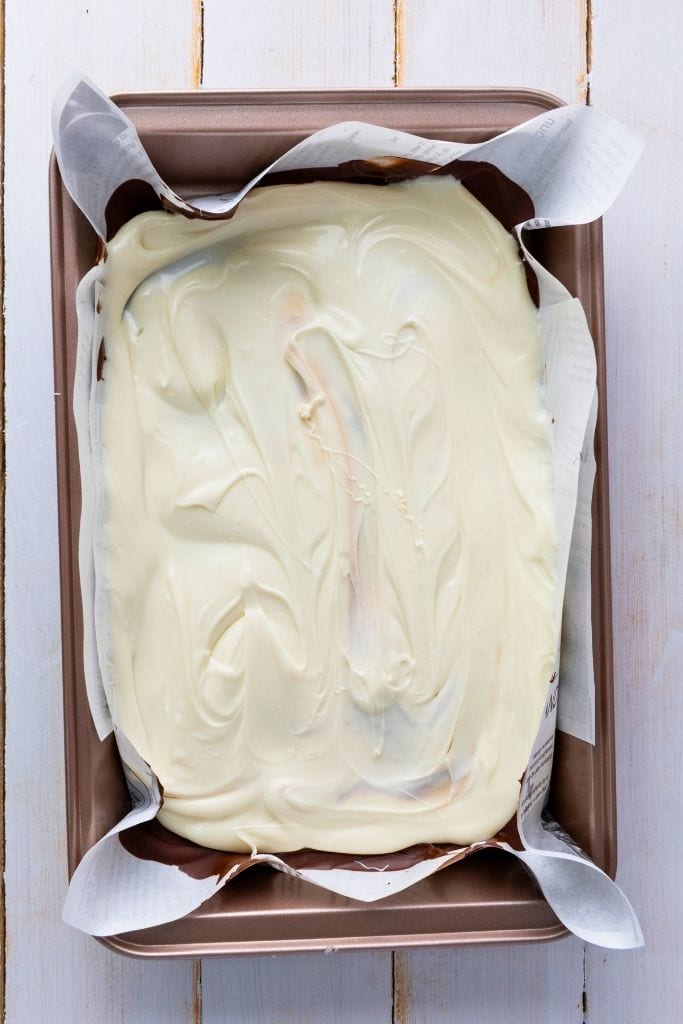 spreading melted white chocolate in pan.