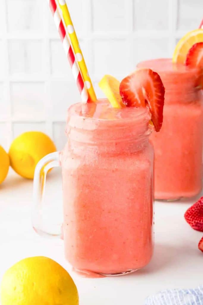 frozen strawberry lemonade in glass with straw.