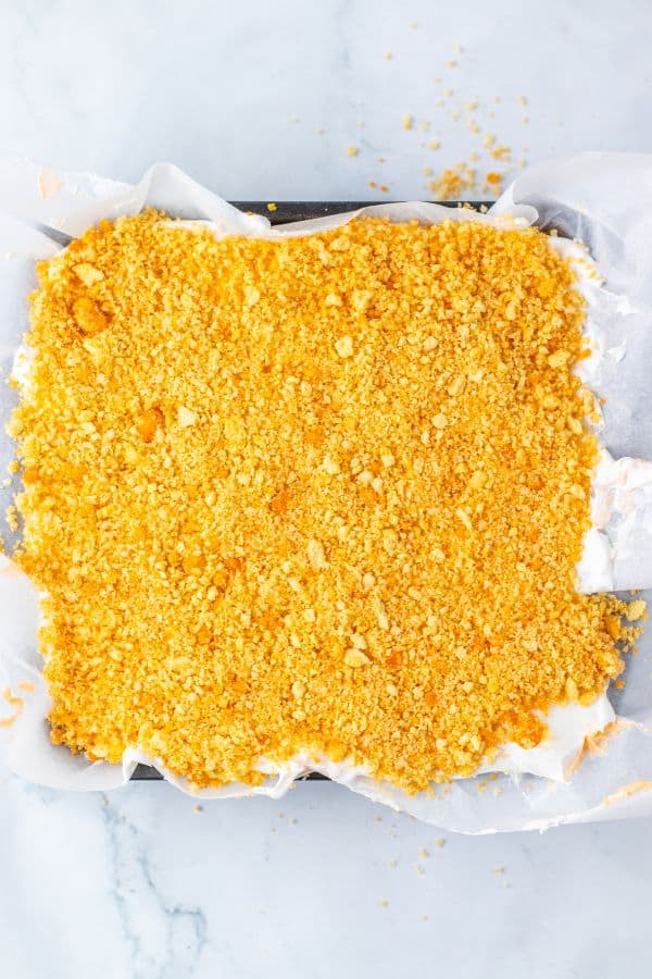 orange creamsicle crunch bars with oreo topping in pan.