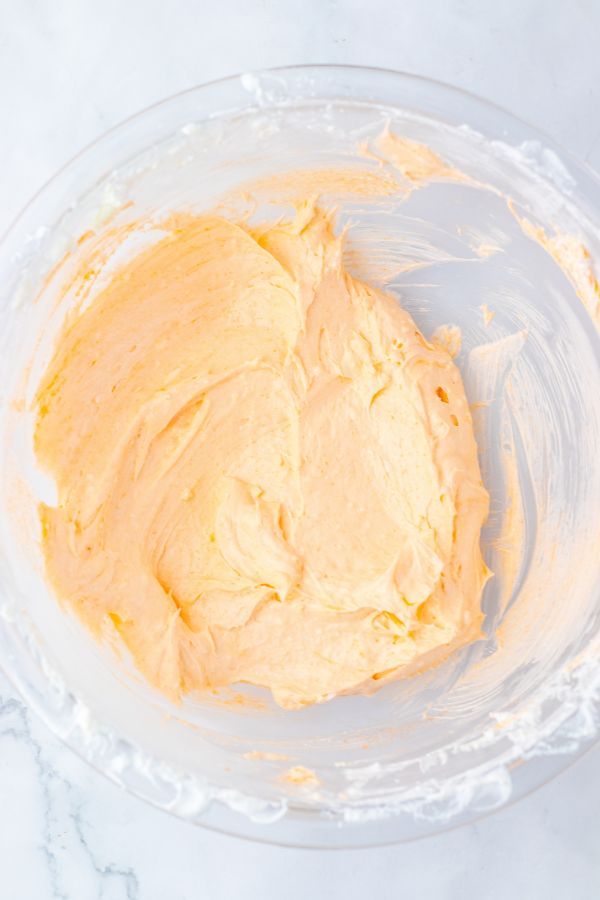 orange jello cheesecake mixture in bowl.