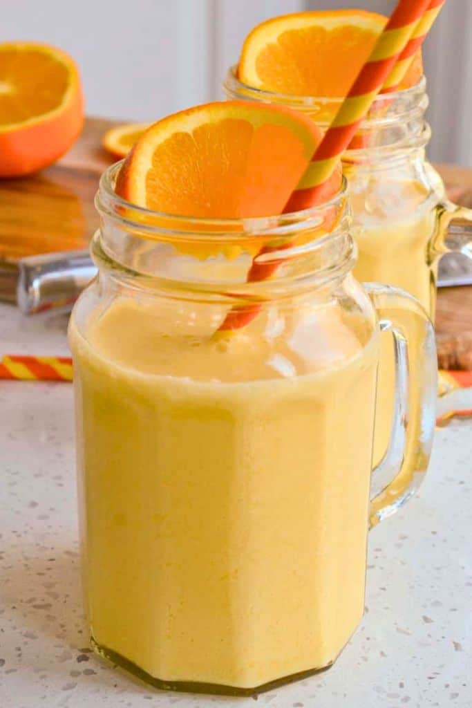 orange creamsicle drink in glass with straw.
