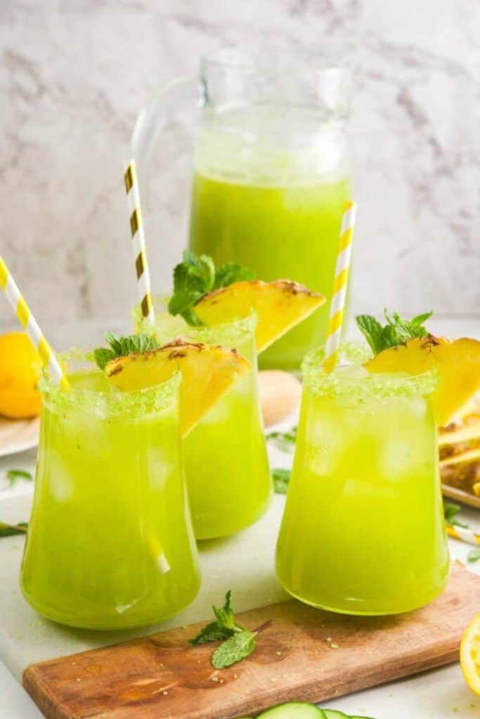 pineapple cucumber lemonade in glasses and pitcher.