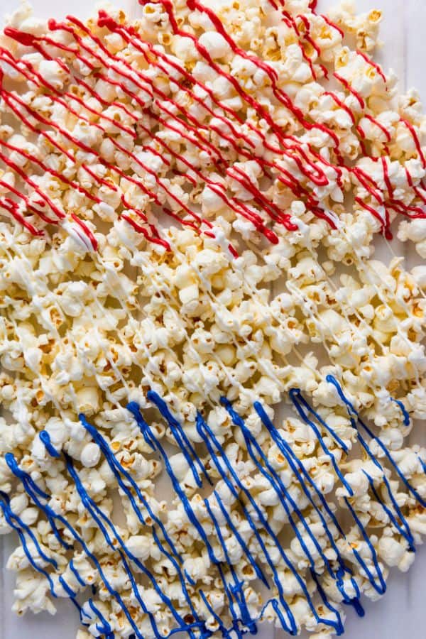 close up of popcorn drizzled with colored melted candy.