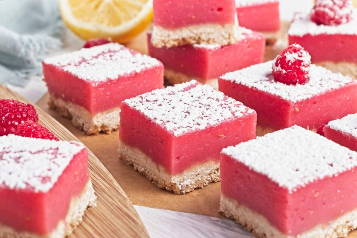 individual raspberry lemon bars dusted with sugar.