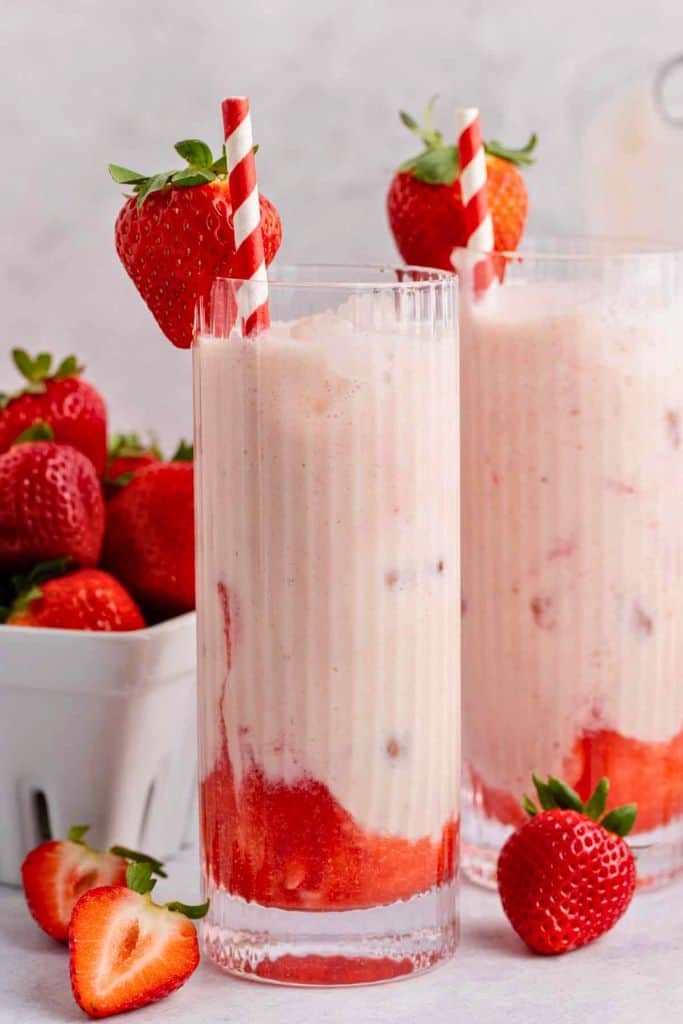 tall glass filled with strawberry horchata drink.