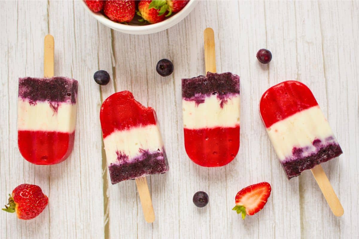 frozen fruit popsicles with bowl of strawberries.