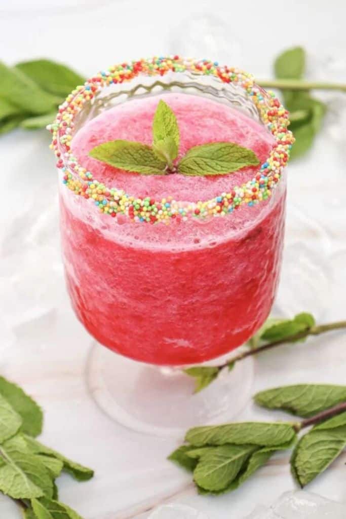 watermelon slushie with sprinkles on rim.