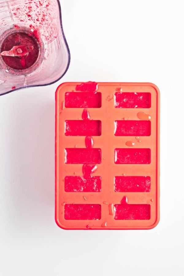 raspberry popsicle mix in molds.