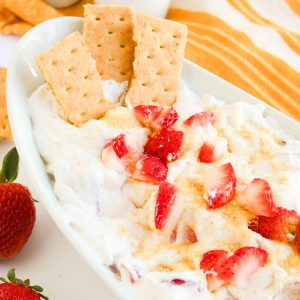 strawberry cream cheese dip in bowl with fresh strawberries.