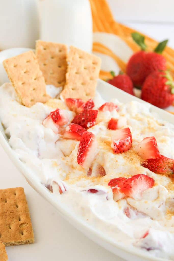 strawberry cheesecake dip in bowl with graham crackers.