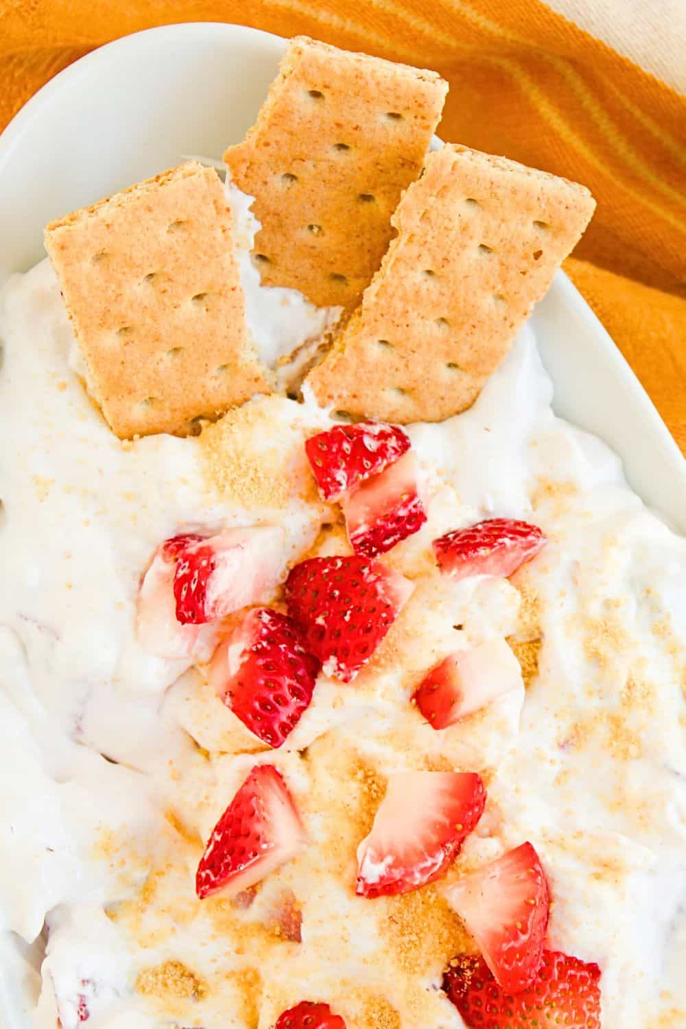 strawberry cheesecake dip in bowl with dipping crackers.