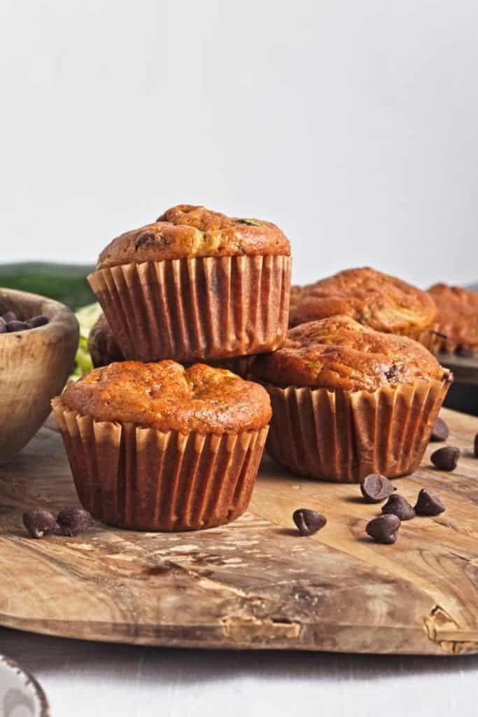 zucchini chocolate chip muffins on wooden platter.