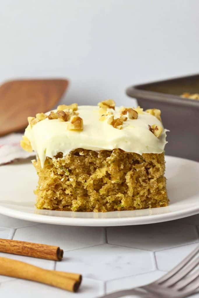 slice of frosted zucchini spice cake with walnuts.