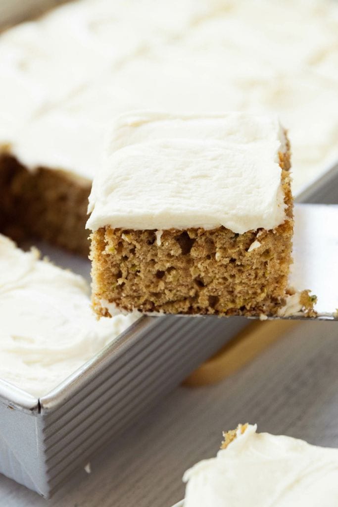 zucchini sheet cake with cream cheese frosting in tray.