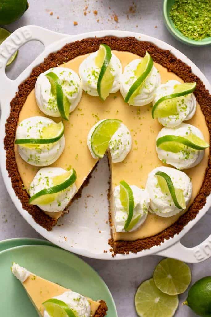 gluten free key lime pie decorated with cream and lime slices.