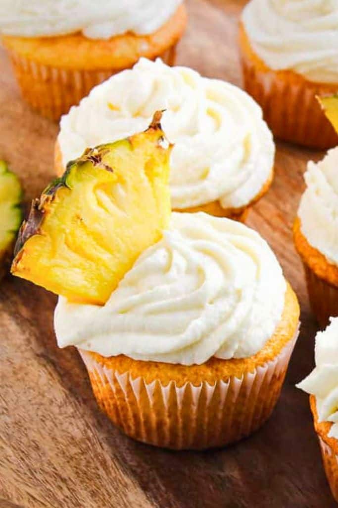 disney inspired dole whip cupcakes with slice of pineapple.