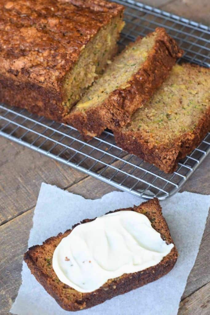 pineapple zucchini quick bread sliced and topped with cream cheese.