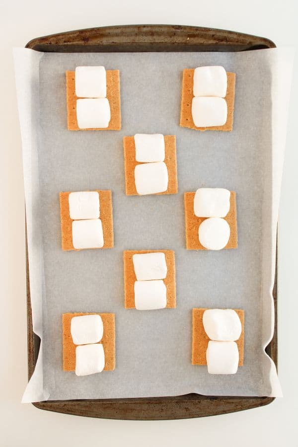graham crackers with marshmallows on baking tray.