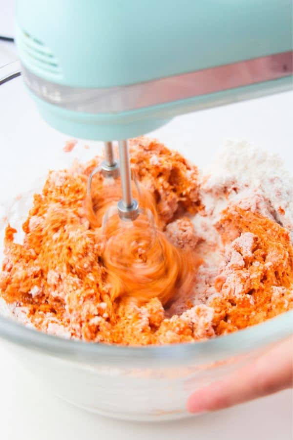 combining cookie ingredients in bowl with mixer.