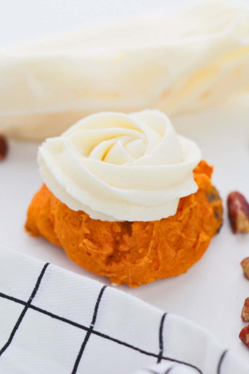 pecan pumpkin cookie with piped cream cheese frosting.