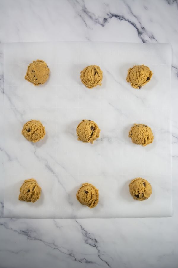raw cookie balls on parchment paper.