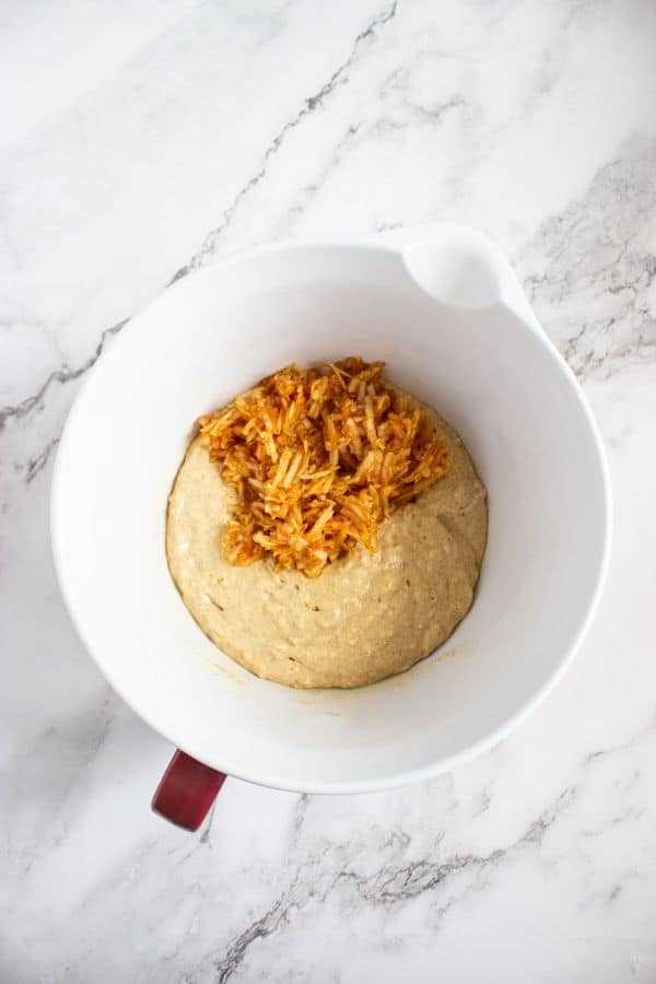 pancake batter with grated apple in bowl.