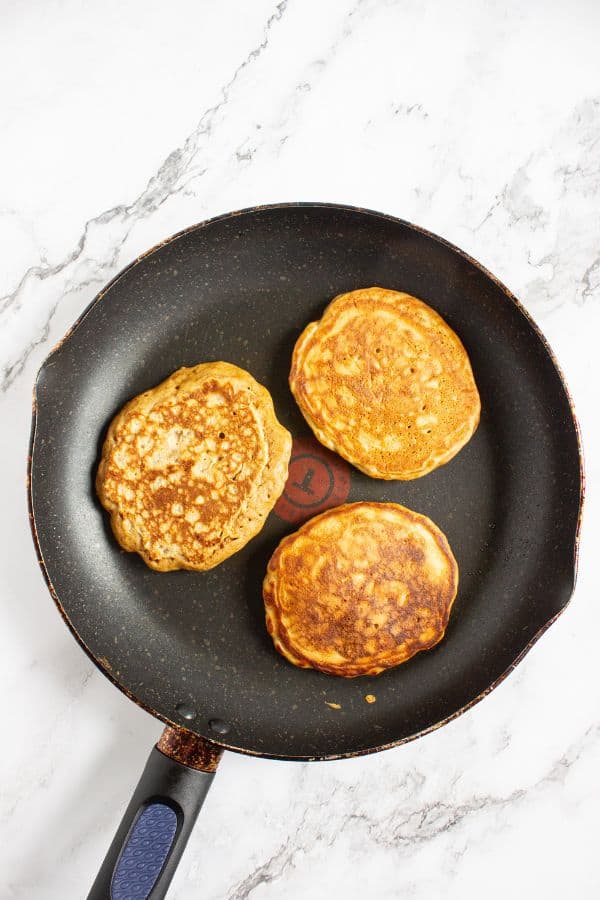 apple pancakes cooking in skillet.