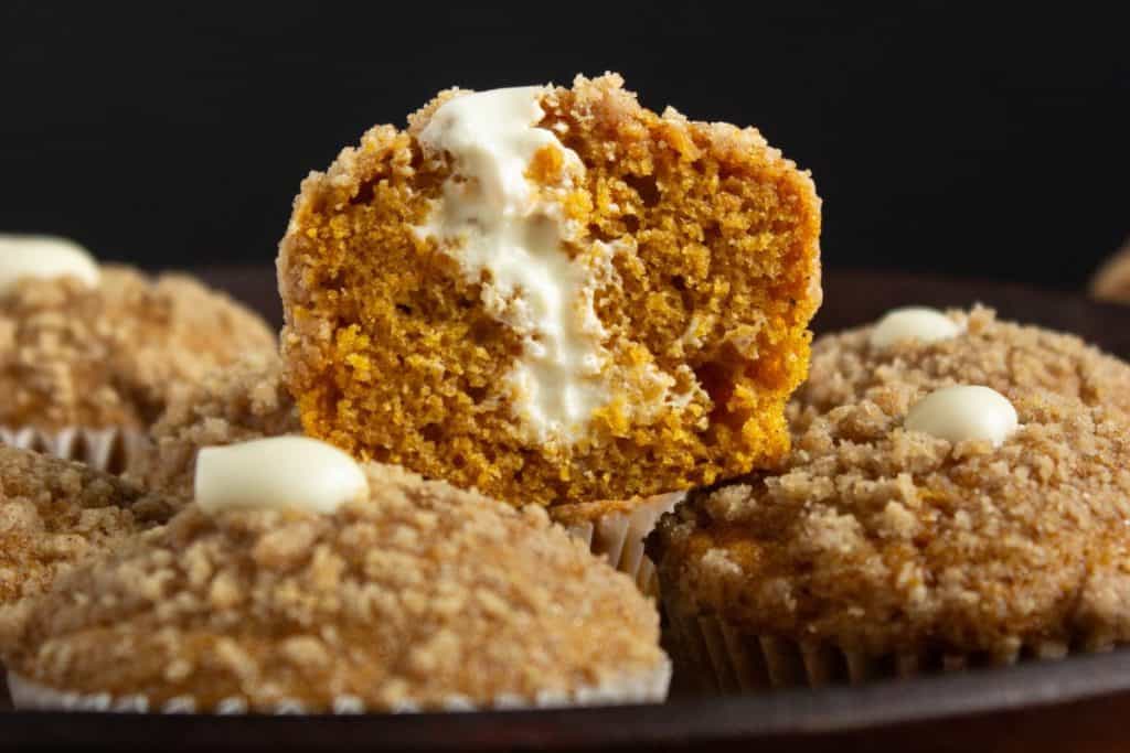 close up of inside a pumpkin cream cheese muffin with streusel topping.