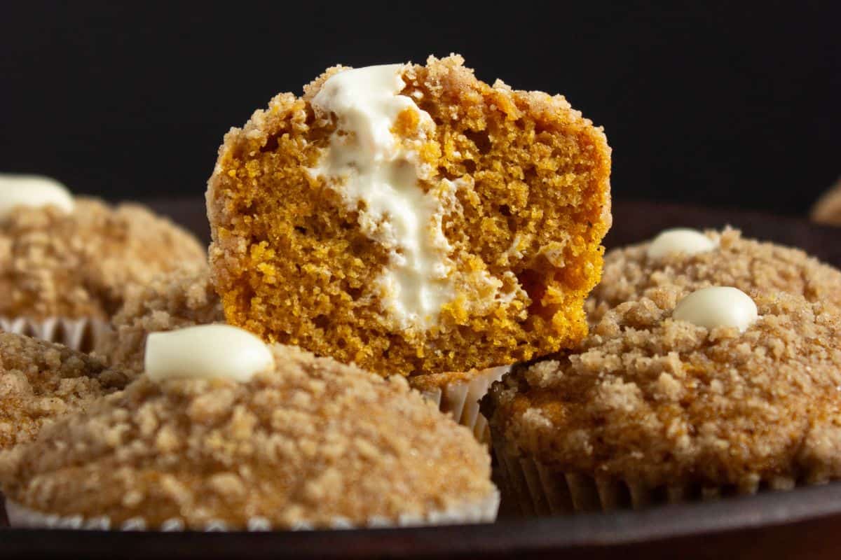 close up of inside a pumpkin cream cheese muffin with streusel topping.