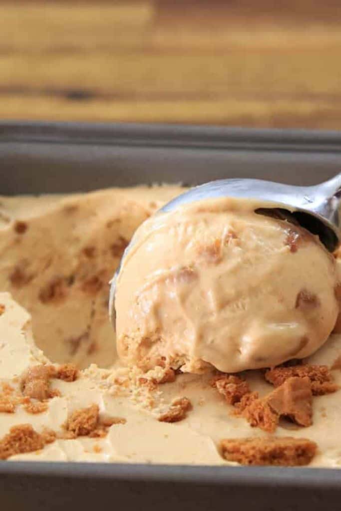 biscoff ice cream in a tub being scooped.