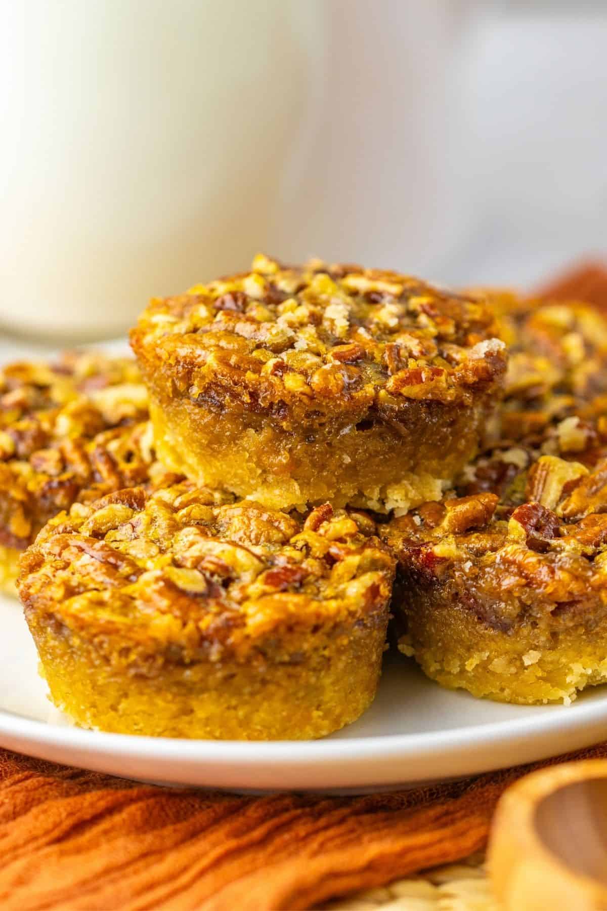 stack of mini pecan pies on plate.