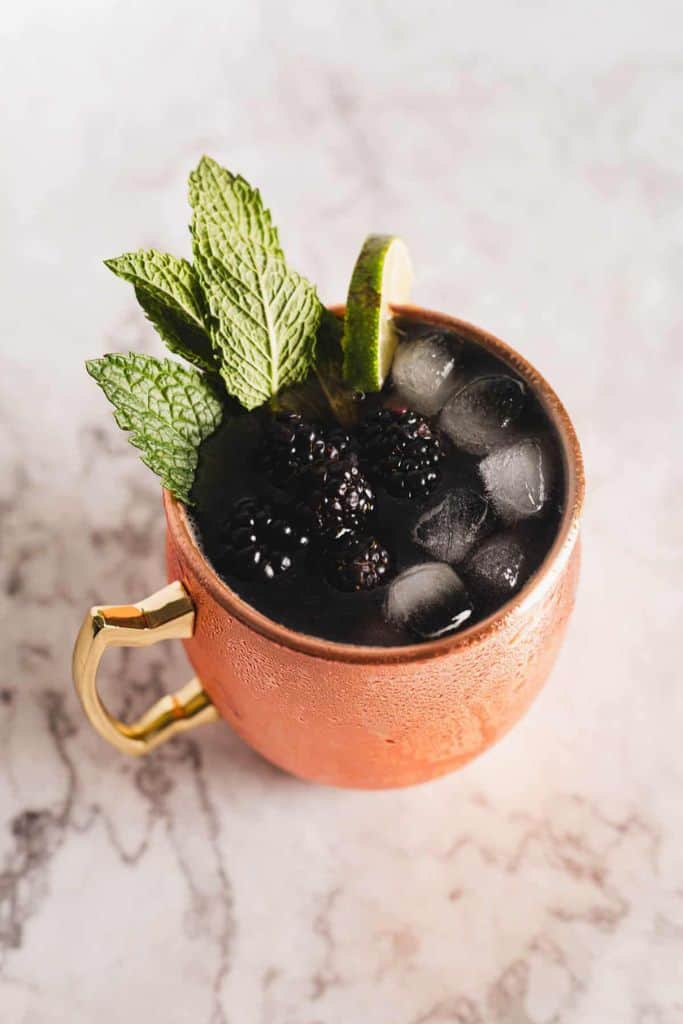 blackberry mocktail in orange cup.