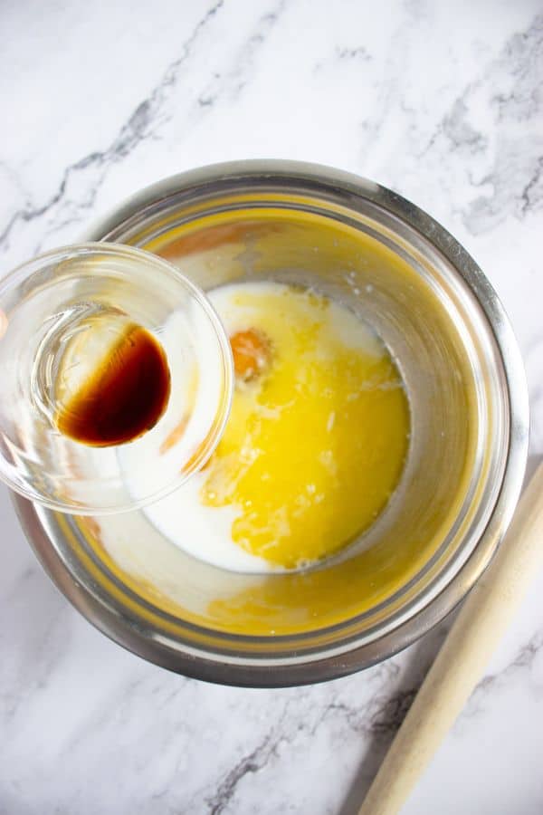 adding vanilla to pancake wet ingredients in bowl.