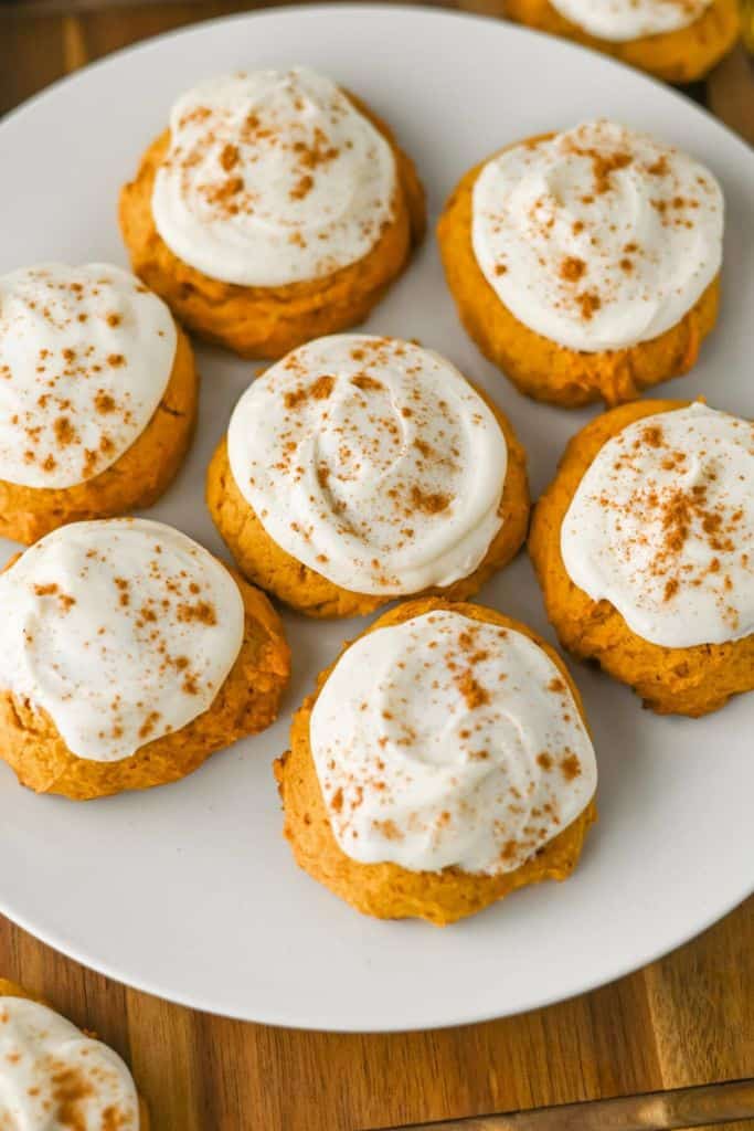 soft pumpkin cookies with cream cheese frosting on plate.