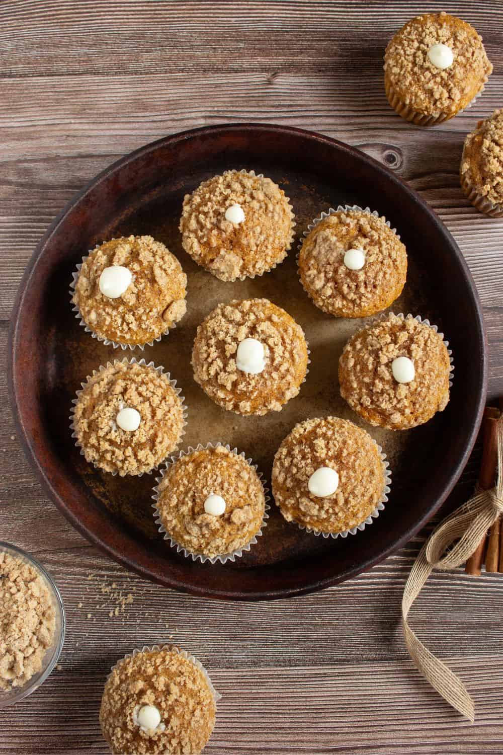tray with pumpkin streusel muffins filled with cream cheese.