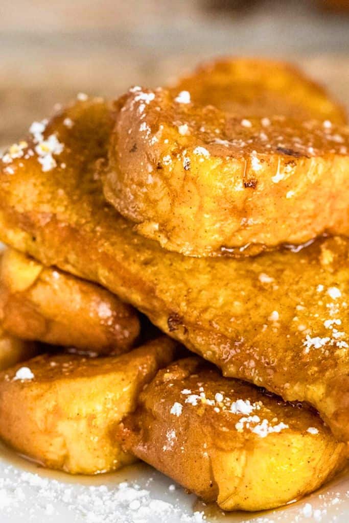 pumpkin french toast sticks stacked and drizzled with syrup.