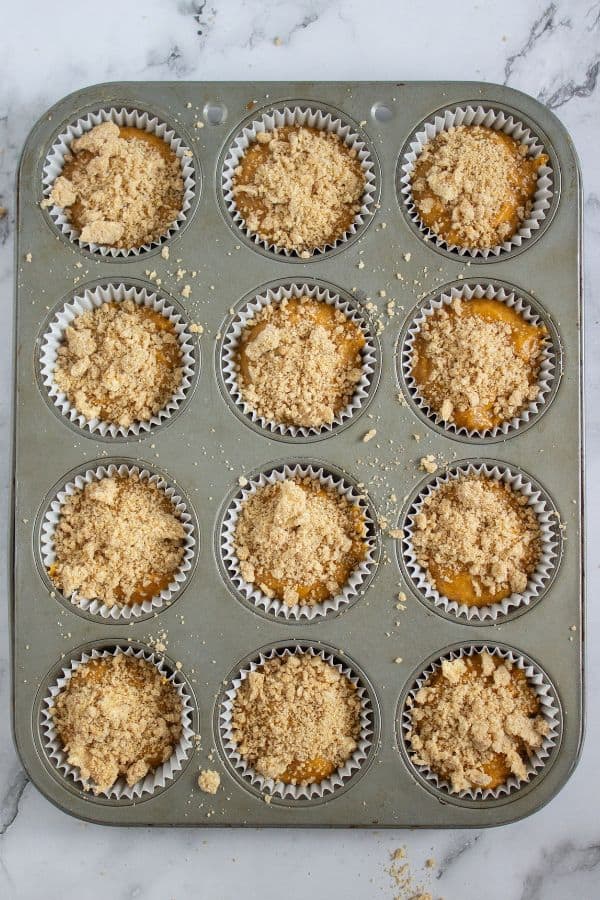 pumpkin muffins with crumble topping in muffin tray.