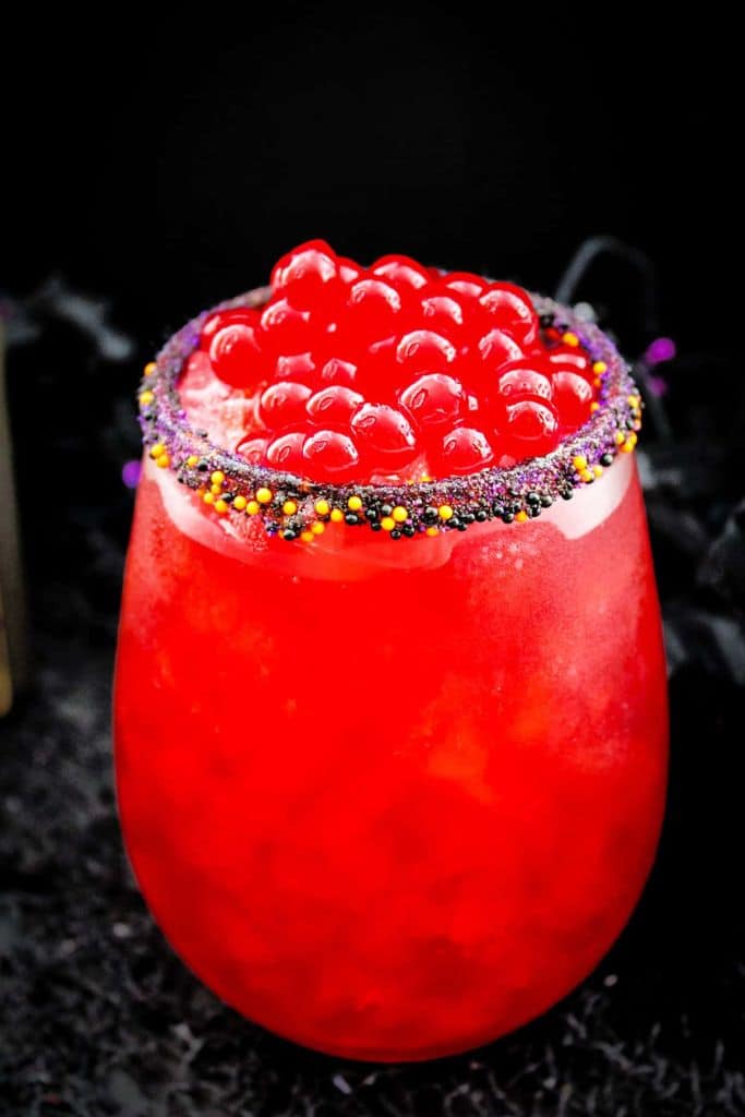 red cocktail with pearls in glass.